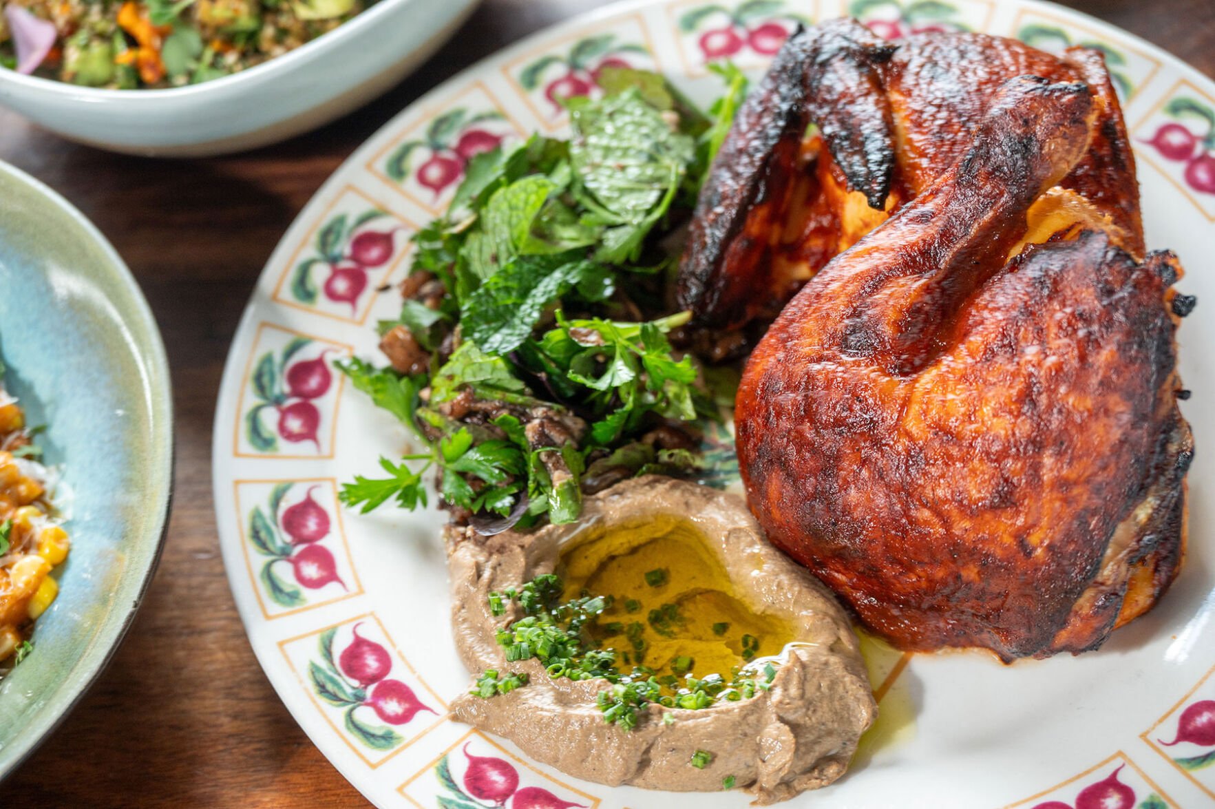 Plated chicken and vegetables with hummus at Butcher & Bee