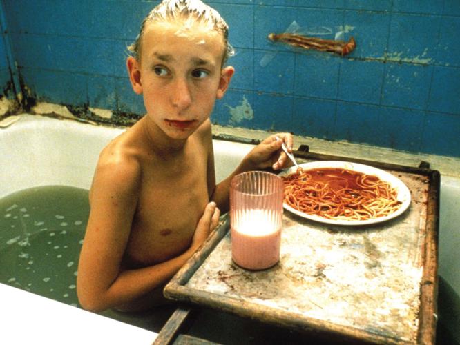 Jacob Reynolds in Gummo, sitting in a bathtub, eating spaghetti