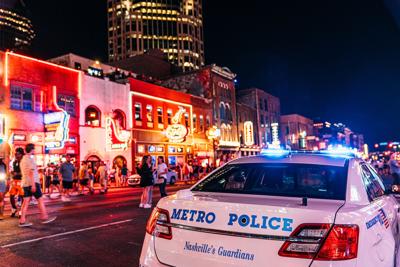 MNPD cruiser in the foreground, Lower Broad honky-tonks and tourists in the background