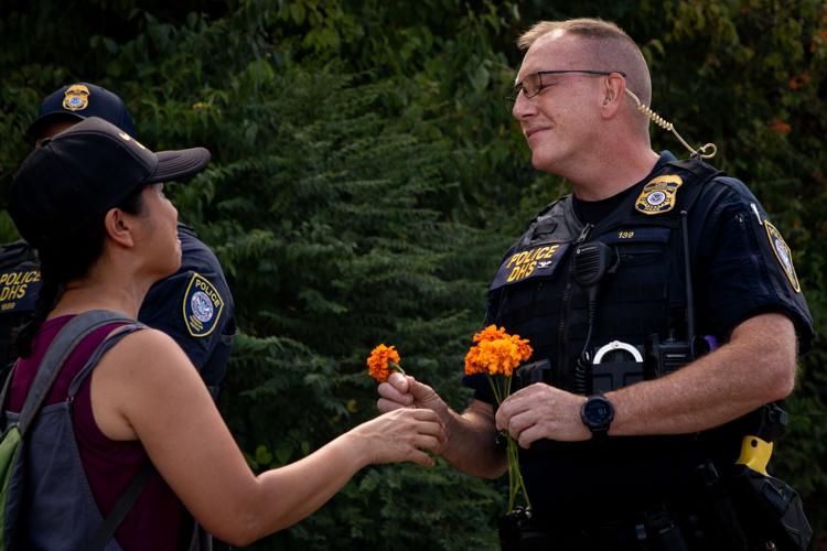 Protester hands flower to DHS officer