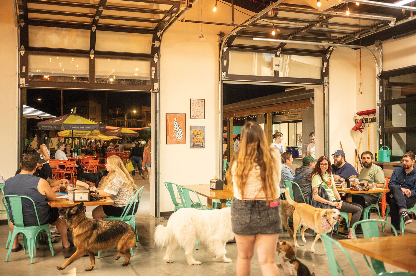 A crowd of people and dogs enjoy the patio at Urban Dog Bar