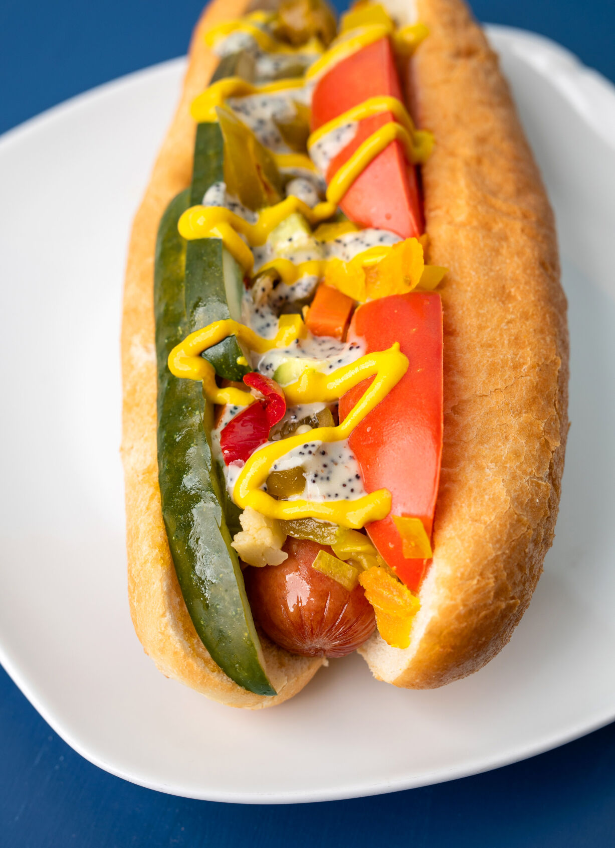 An all-beef Vienna wiener with slaw, tomato, hot giardiniera, dill pickle, yellow mustard and hot poppy cider dressing