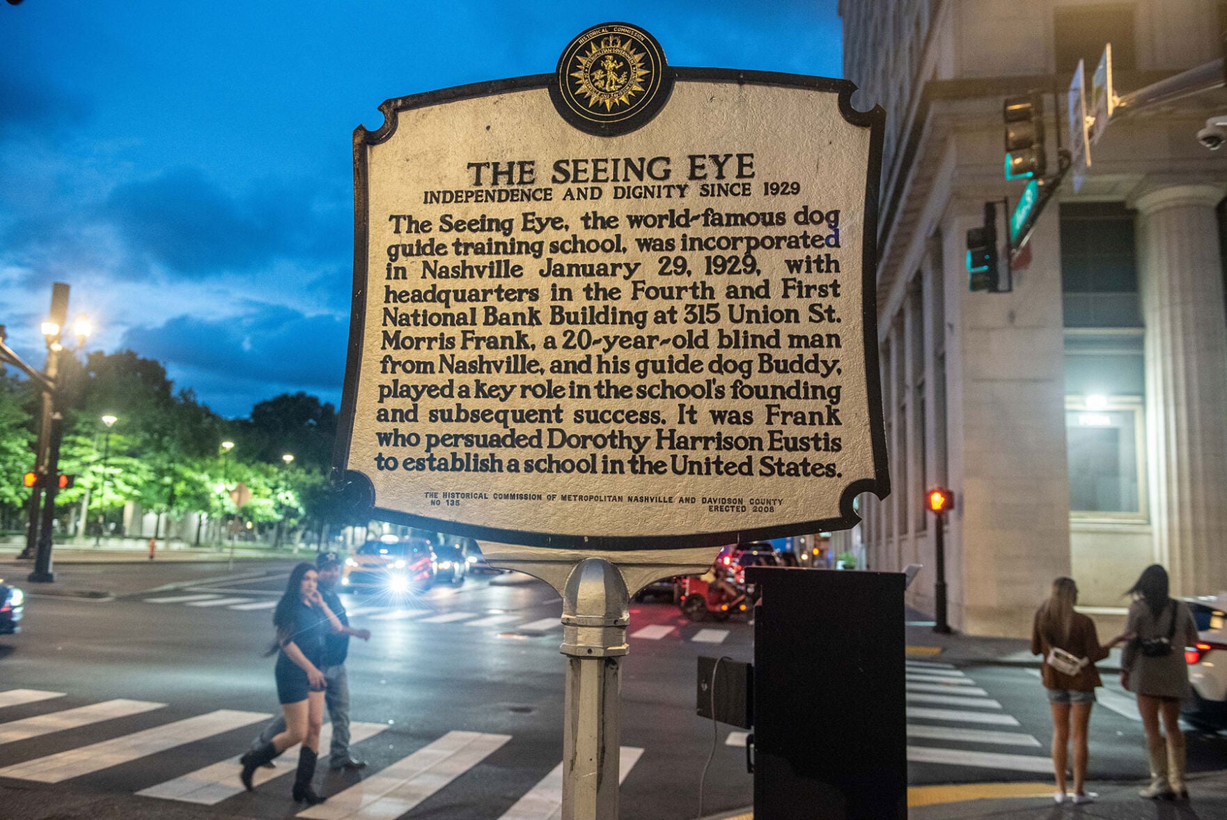 A historical marker that reads:
“THE SEEING EYE
“INDEPENDENCE AND DIGNITY SINCE 1929
“The Seeing Eye, the world-famous dog guide training school, was incorporated in Nashville January 29, 1929, with headquarters in the Fourth and First National Bank Building at 315 Union St. Morris Frank, a 20-year-old blind man from Nashville, and his guide dog Buddy, played a key role in the school's founding and subsequent success. It was Frank who persuaded Dorothy Harrison Eustis to establish a school in the United States.”
