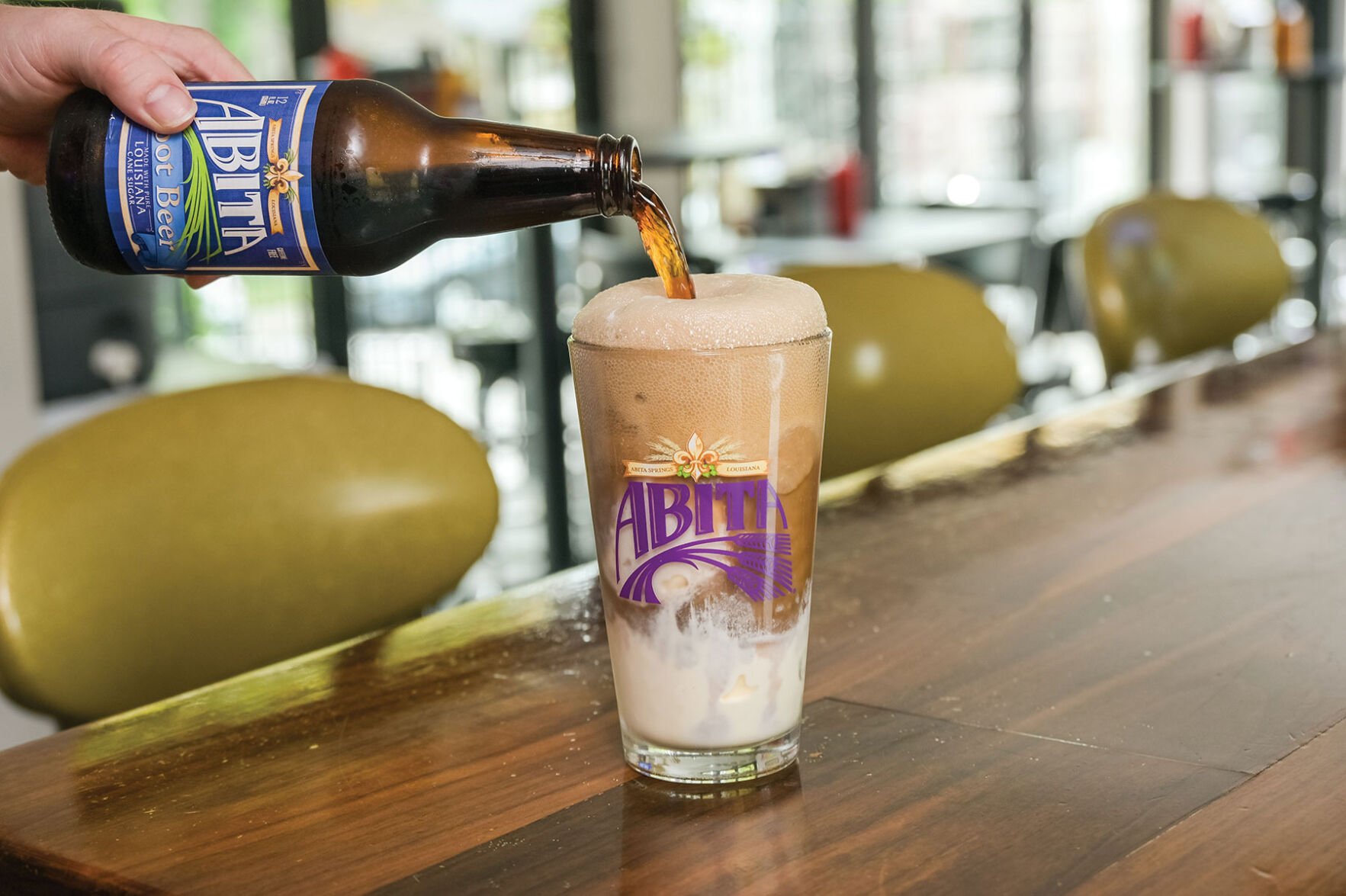 A bottle of Abita poured into a foamy glass with ice cream.