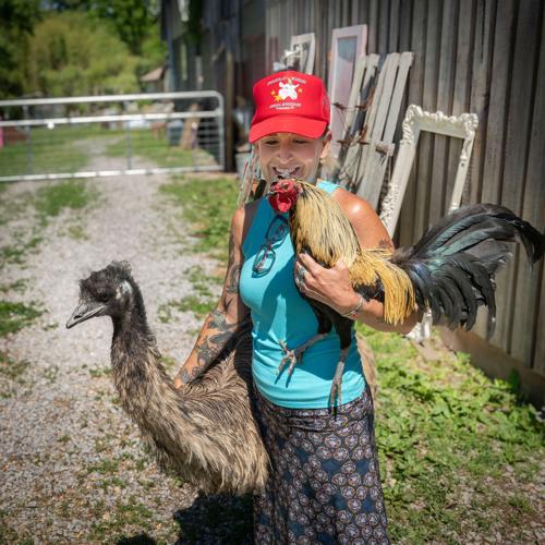 Bonnie Glueck with a rescued rooster and emu at Piccolo Farms