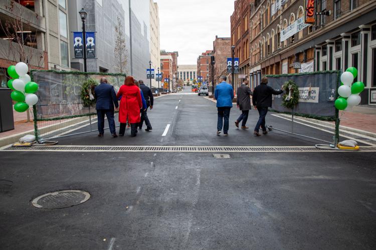 A group of people open the gate blocking off Second Avenue