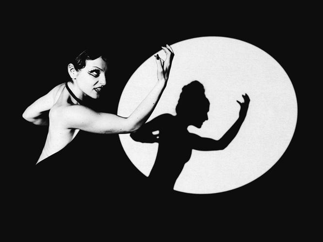 Black and white photo of artist book NOT brooke making an aggressive silhouette in a spotlight