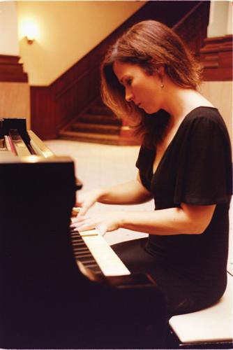 Color photograph, taken in 2005, of April McLean playing piano in the Grand Lobby of the Union Station Hotel
