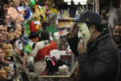 A customer tries on a Halloween mask in Chicago, October 2011