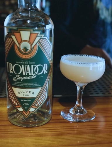 A bottle of Trovador rum next to a cocktail