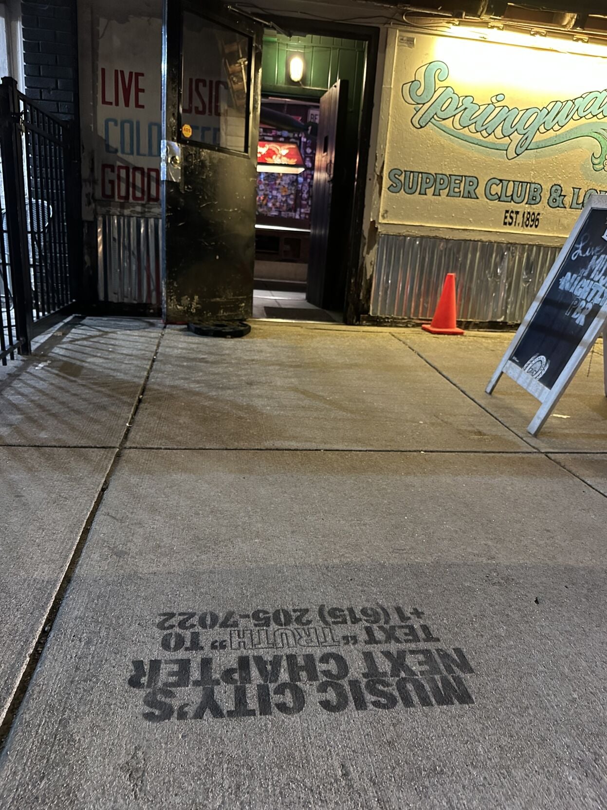 Photo of the front facade of Nashville venue Springwater, with an ad for forthcoming venue The Truth spraypainted on the sidewalk. The ad reads “Music City’s Next Chapter Text “TRUTH” to (615) 205-7022”
