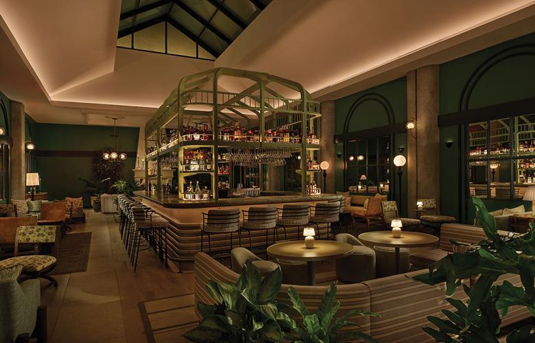A sleek restaurant with a cage-like structure over the bar housng bottles and glasses