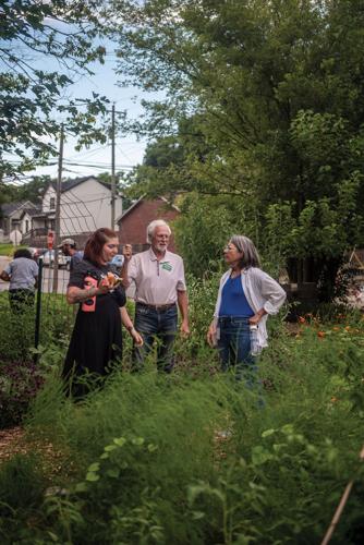 Color photo of three people speaking in an outdoor green space during a community event at Nashville Food Project's Hope Gardens