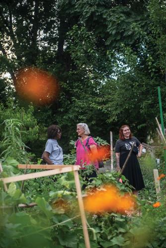 Color photo of three people speaking in an outdoor green space during a community event at Nashville Food Project's Hope Gardens in July 2026