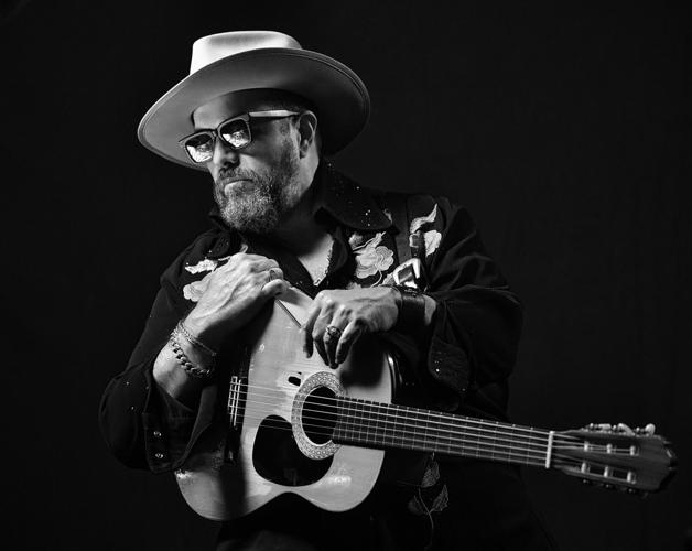 Raul Malo black and white press photo 2025 artist with an acoustic guitar and cowboy hat