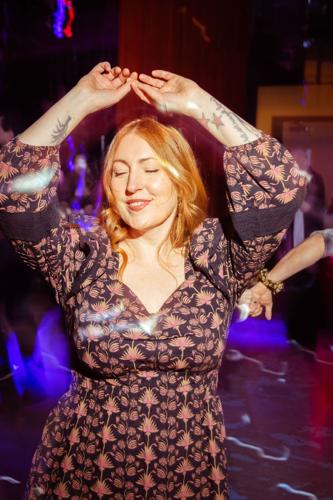 A woman dancing with her hands raised above her head