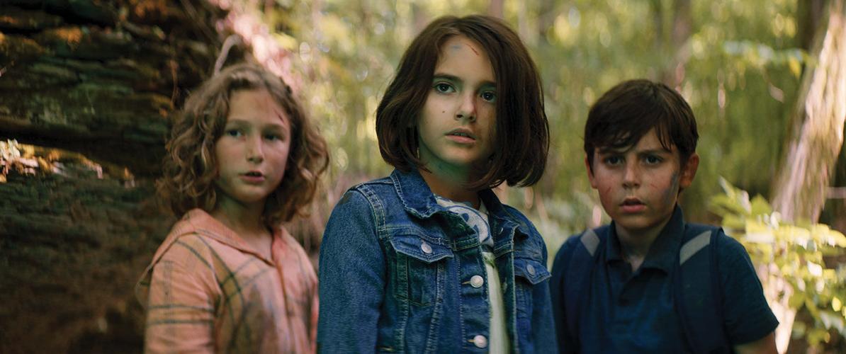 Three children from the movie 'Sketch' stare at something out of frame in disbelief