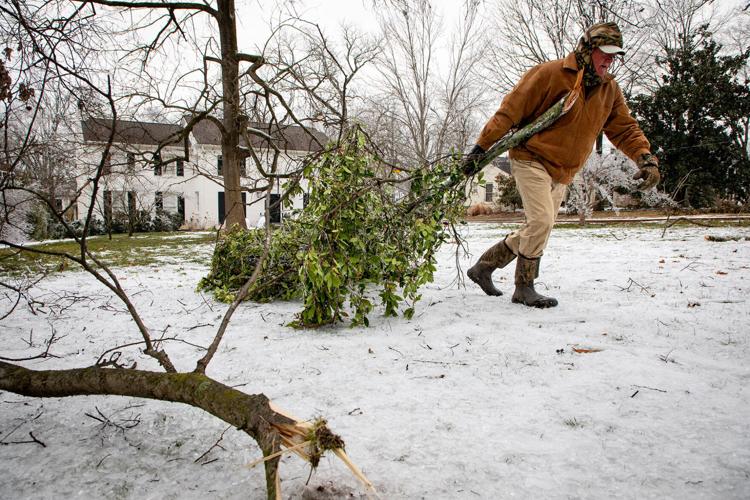 Tad Porter drags branches from the yard of his Estes Road home.
