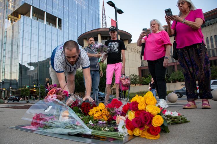 Gary and Cameron Simms and Shawn Carney, all of Columbia, lay flowers down at a makeshift memorial at Dolly Parton’s star outside of Nashville’s Country Music Hall of Fame and Museum hours after Parton’s death was announced, Aug. 25, 2026