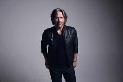 Kip Winger press photo 2025 artist stands in a black leather jacket against a gray background