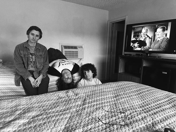 Black and white press photo of the three band members sitting on a hotel bed.