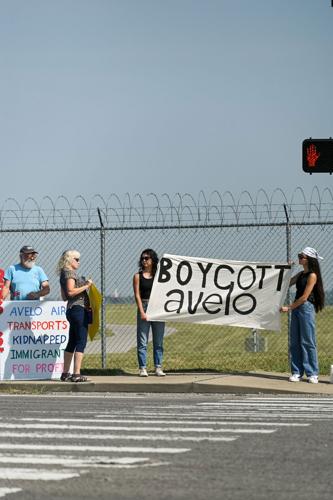 Protesters at the end of a crosswalk holding a banner reading "Boycott Avelo"