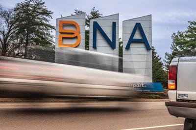 Cars speed by the BNA sign outside the Nashville airport