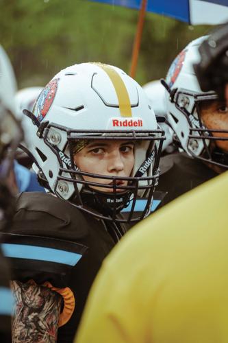 A player from the Tennessee Trojans of the National Women's Football Conference looks up from the huddle and into the camera