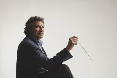Giancarlo Guerrero former music director Nashville Symphony press photo conductor holding baton stands against white background