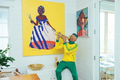Two paintings surround Shabazz Larkin, the Nashville Scene’s 2026 Best Visual Artist in Nashville