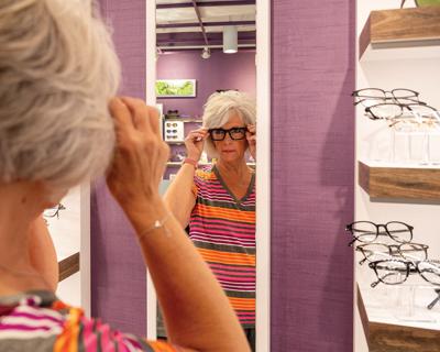 A woman tries on glasses at Optique, the Nashville Scene’s 2026 Best Place to Buy Eyewear in Nashville