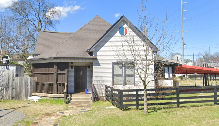 A white building with a fenced lawn on Illinois Avenue