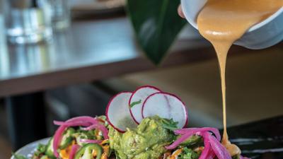AVO’s Coconut Queso pours onto an entre, the Nashville Scene’s 2026 Best Alt Queso in Nashville.
