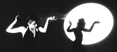 Black and white photo of artist book NOT brooke making a severe silhouette in a spotlight