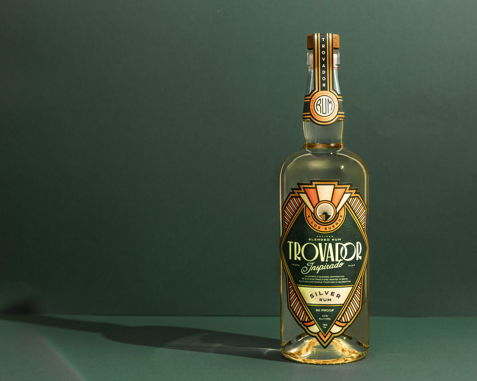 A bottle of Trovador rum against a green backdrop