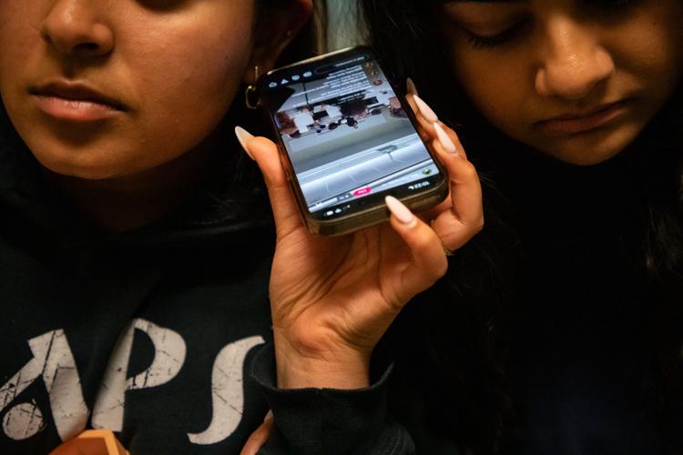 Belmont students gather around a cellphone in the hall of the Janet Ayers Academic Center to listen to a livestream of U.S. Rep. Andy Ogles' student town hall appearance, April 27, 2026