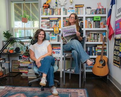 Two City Cast staffers pose with a microphone and copy of The Conirbutor newspaper