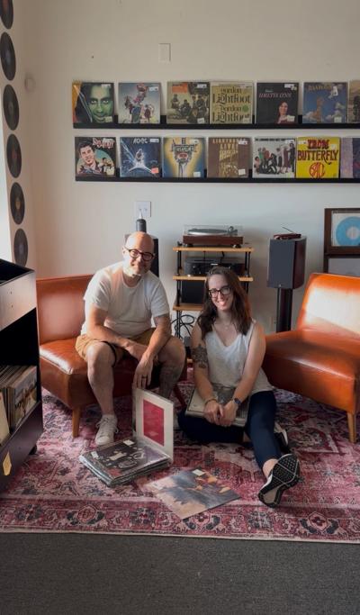Michael and Kate Lovett, owners of the new Runout Record Shop, pose in their home with a selection of vinyl and their stereo