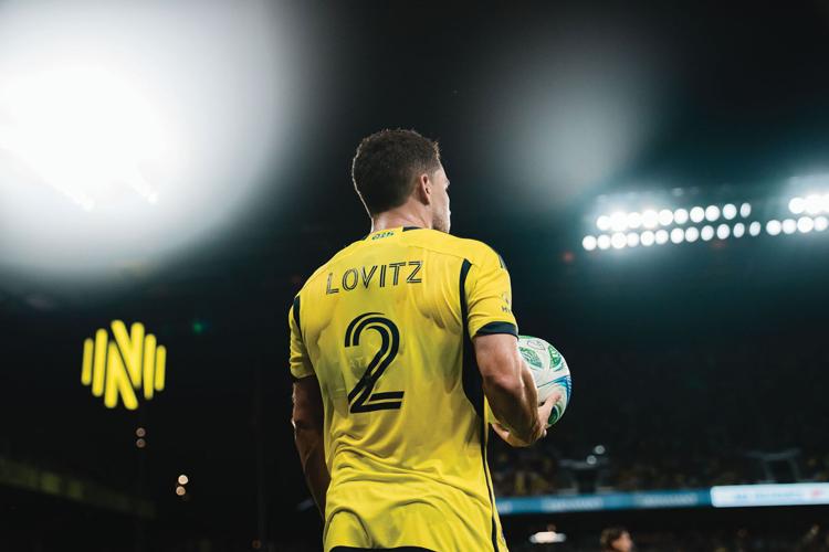 Nashville SC player Lovitz from the back, holding the soccer ball in his right hand