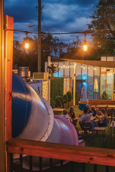 A tubular slide leading down to a patio of diners at Playdate, which is our Writers' Choice for Best 12South Respite in Nashville 2026.