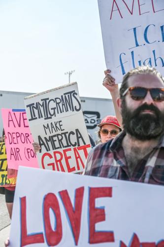 Protesters hold signs condemning Avelo Airlines