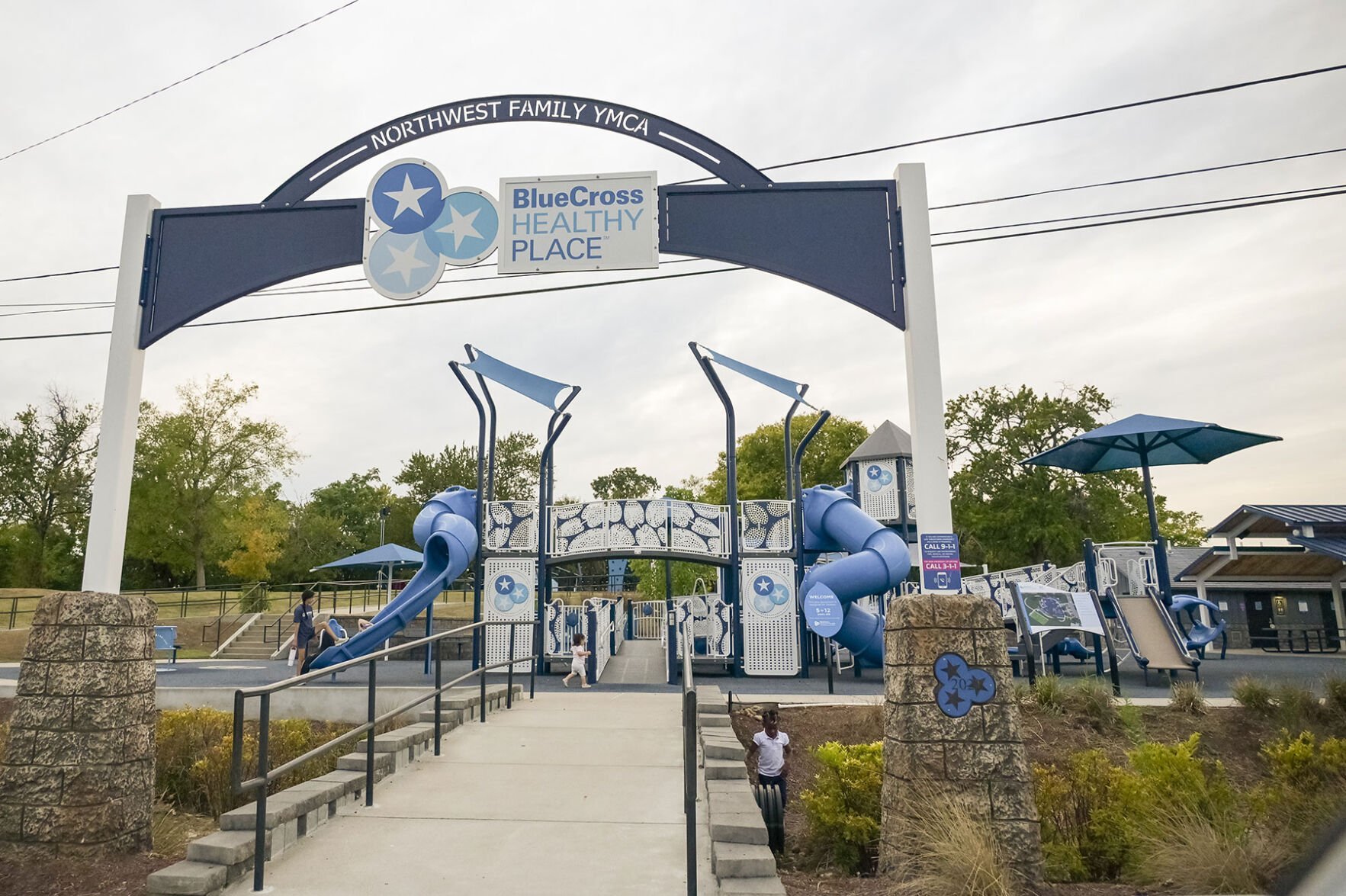 The blue-and-white arched entrance to BlueCross Healthy Place at the Northwest YMCA with a big elaborate slide behind it.