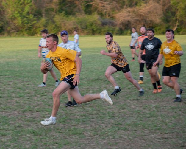 Members of the Nashville Rugby Football Club run down the field during a game