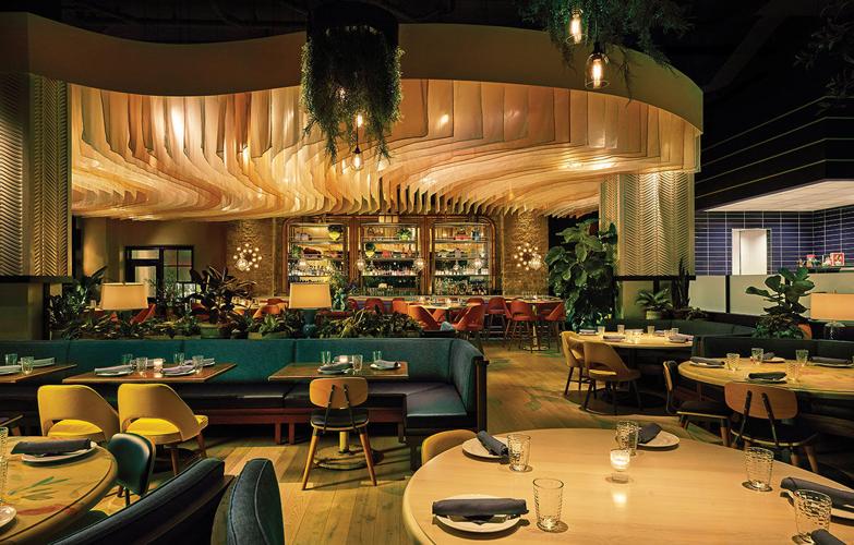 A sleek modern dining room with a curved ceiling over the bar