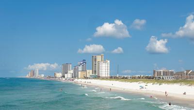 An ocean shoreline with hotels on the horizon