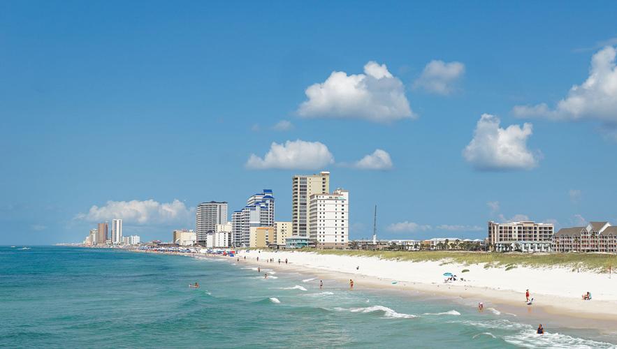 An ocean shoreline with hotels on the horizon