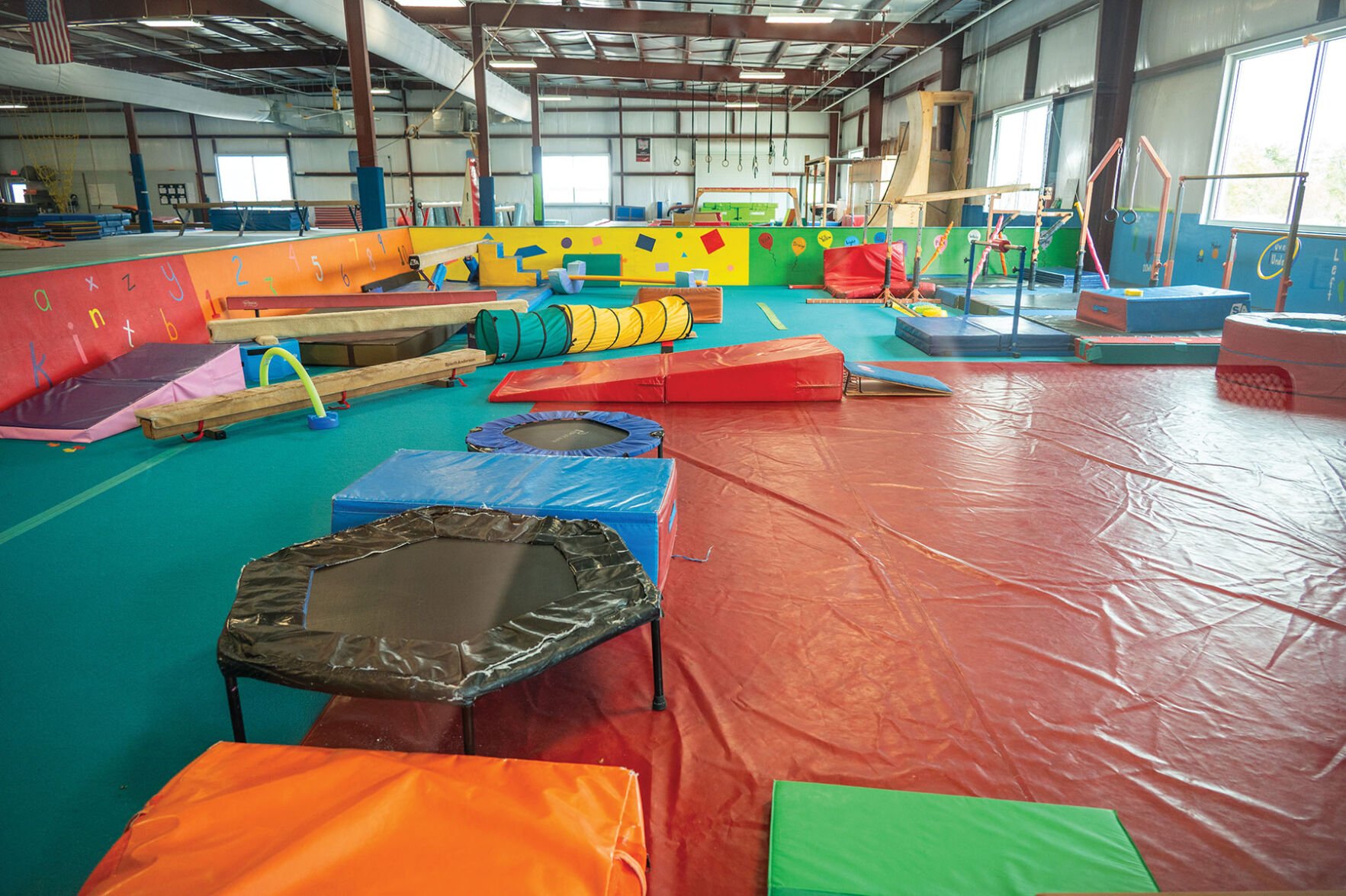 Trampolines, ramps and gymnastic equipment in a colorful gym space