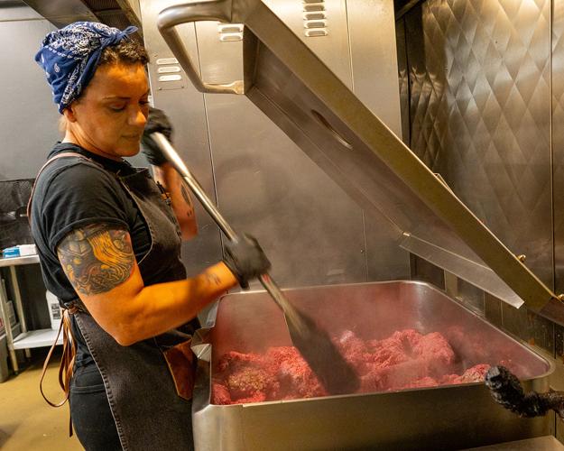 An employee at Nicoletto's preparing food