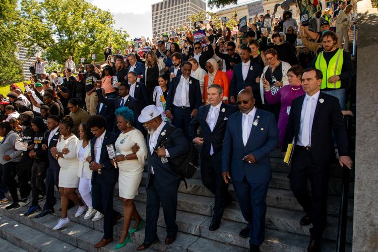 Democratic lawmakers and activists walk down the steps of the Capitol, May 7, 2026