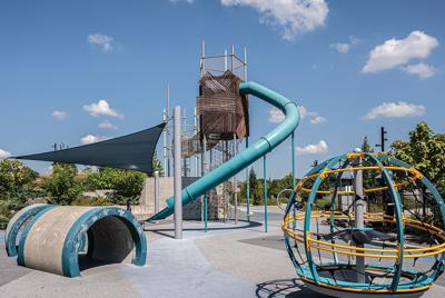 A tall curved slide looms over playground equipment at Mill Ridge Park, the Nashville Scene's Writers' Choice for Best Playground Slides.